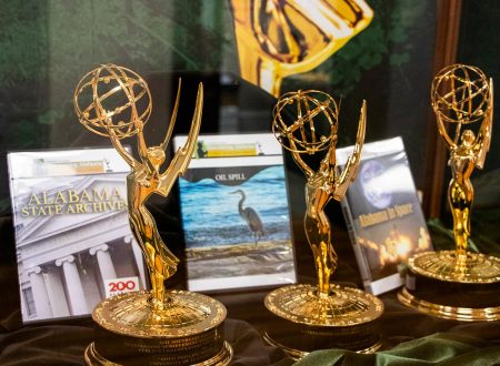 three Emmy trophies on display with Discovering Alabama DVD cases